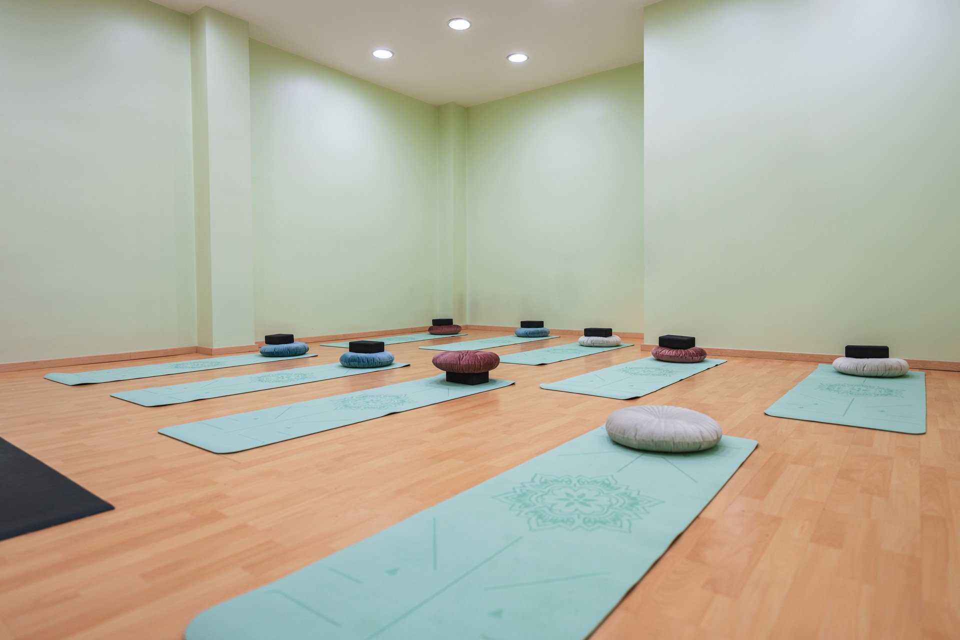 Empty yoga studio with yoga mats and pillows ready for class